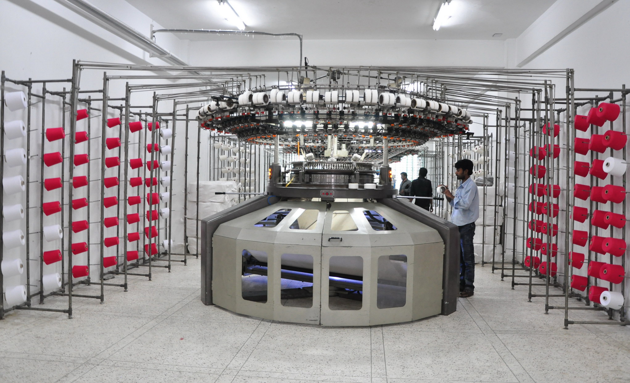 Fabric rolls and knitting floor workers in a modern textile factory